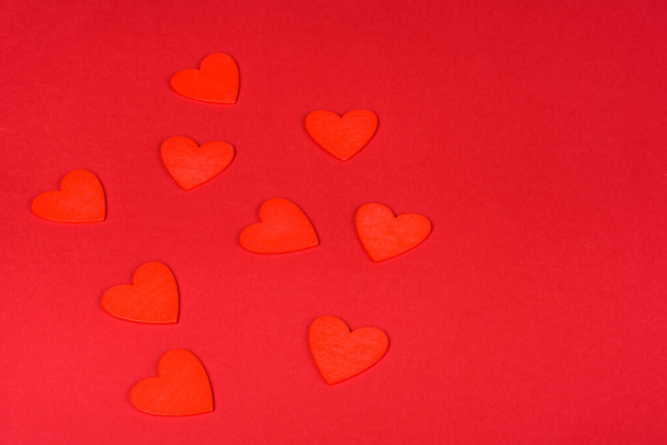 Several figures in the shape of hearts on a red one-ton background. Celebrating Valentine's Day - Photo, Image