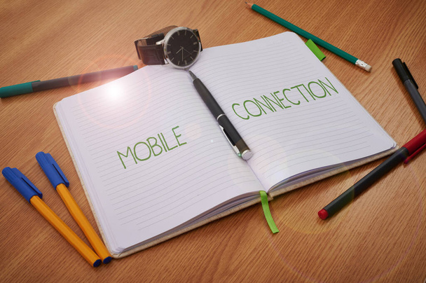 Inspiráció, ami a Mobile Connection jelét mutatja. Koncepció jelentése Biztonságos univerzális bejelentkezési megoldás mobiltelefonnal Üres notebook karóra körülvéve szétszórt írószerekkel. - Fotó, kép