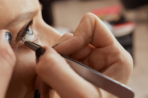 Eyelash Extension Procedure. Woman Eye with Long Eyelashes. Lashes. Close up, selected focus. - 写真・画像