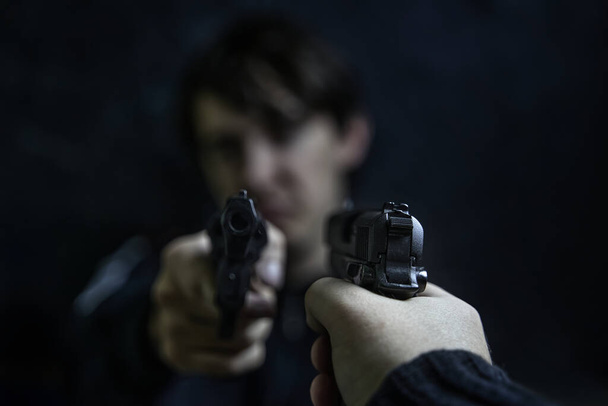 Mann mit Pistole auf Verbrecher mit Revolver gerichtet. - Foto, Bild