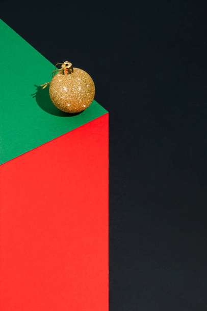 3D render of gold Christmas bauble on paper cube. Trendy Christmas design color background. New Year concept. Abstract composition. - Zdjęcie, obraz