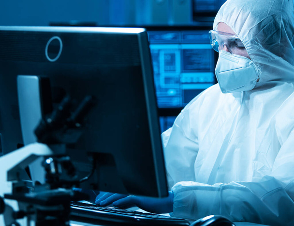 The scientist works in a modern scientific laboratory for the research and development of microelectronics and processors. Microprocessor manufacturing worker uses computer technology and equipment. - Фото, зображення