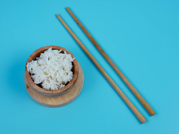 arroz en un tazón de madera pequeño y palillos. - Foto, imagen
