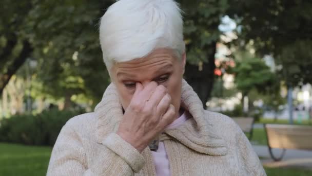 Closeup of middle-aged woman reduces eye strain closed eyes touch rubs nose bridge, sad elderly unhealthy lady of retirement age feels unwell exhausted depressed weary dizzy tired thinking of problems - Filmagem, Vídeo