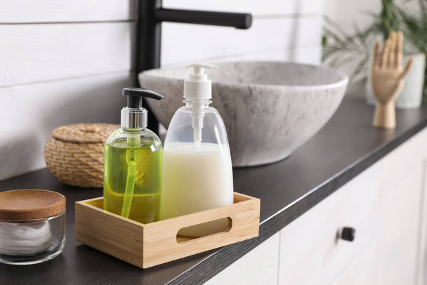 Dispensers with liquid soap on countertop in bathroom - Фото, зображення