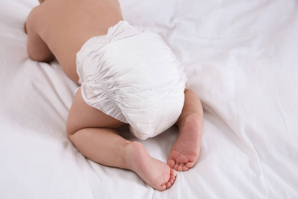 Cute baby in dry soft diaper on white bed, closeup - Foto, immagini