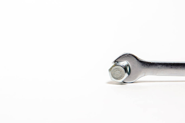 Концепція промисловості, металевий срібний гайковий ключ з гвинтом у ньому на білому тлі
 - Фото, зображення