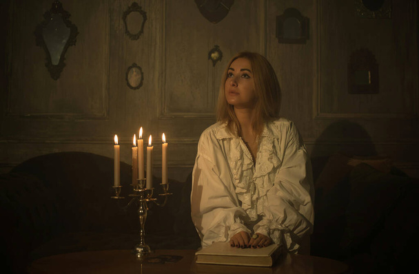 Vrouw met kaarsen voor noodlotsvoorspelling 's nachts, details van heksenrituelen, occultisme concept - Foto, afbeelding