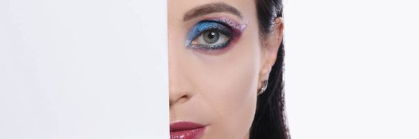 Half face of young sexy woman with burgundy lipstick and bright eye makeup closeup - Foto, imagen