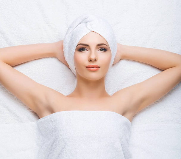 Young and healthy woman gets massage treatments for face, skin and neck in the spa salon. Health, wellness and rejuvenation concept. - Photo, image