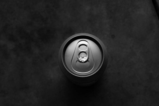 black and white photo of a beer can on a dark background - Foto, Imagen