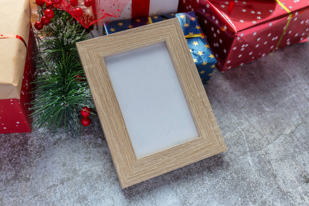 Wooden frame, Christmas gifts in the background - Фото, зображення