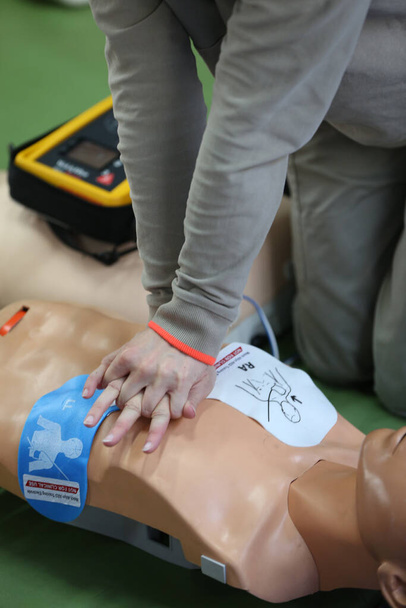 Warsztaty organizowane przez Czerwony Krzyż. Pierwsza pomoc ratująca życie modelce. Defibrylator. Francja.  - Zdjęcie, obraz