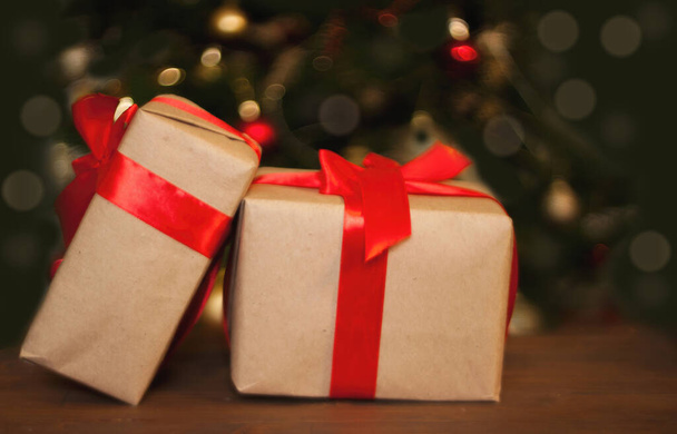 Noel ağacının arka planında masanın üzerinde iki tane hediye kutusu var.. - Fotoğraf, Görsel