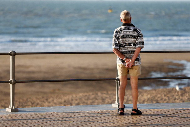 Συνταξιούχος που βλέπει τη θάλασσα. Δυτική Φλάνδρα. Βέλγιο.  - Φωτογραφία, εικόνα