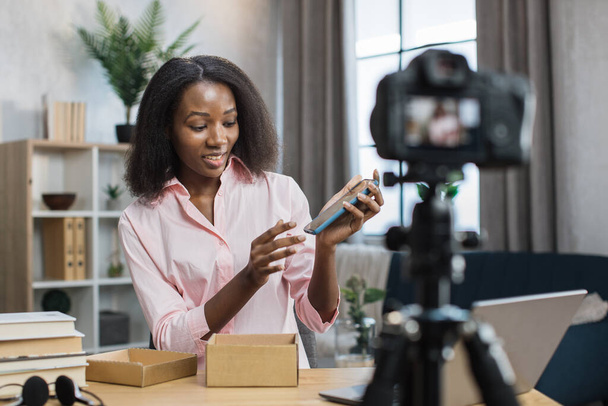 Woman filming video while opening box with new mobile - Fotoğraf, Görsel