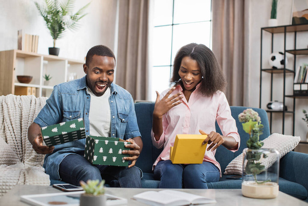 African american man and woman opening colorful gift boxes - Photo, Image
