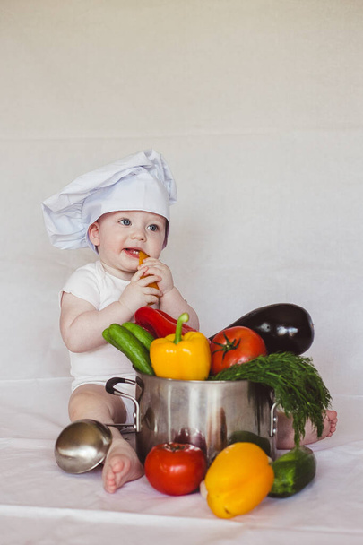 Healthy nutrition Happy little boy in hat prepares a vegetable salad. Cook - Фото, изображение