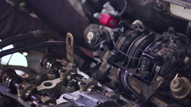 修理工場で不完全な車のエンジンを修理車マスターズの撮影を閉じます. - 映像、動画