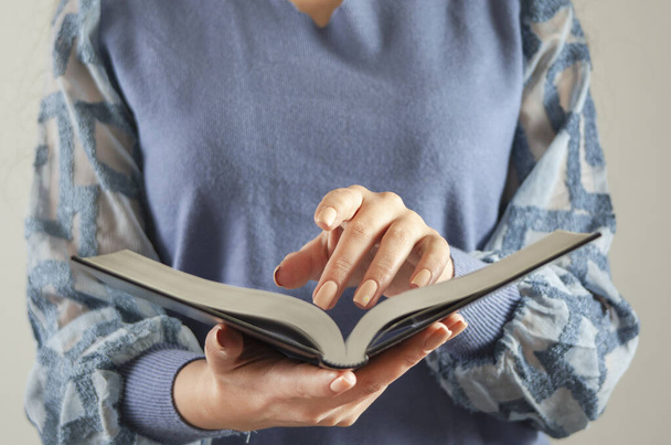 молодая женщина держит и читает Святую Библию - Фото, изображение