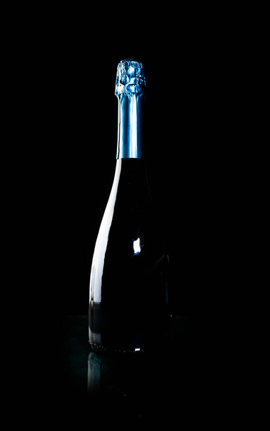 bottle of champagne on a black handicap with fireworks - Фото, зображення