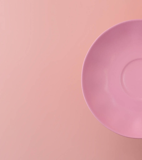 half pink plate on pink background. copy space and flatlay - Zdjęcie, obraz