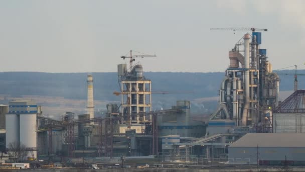 A magas gyárszerkezetű cementgyár és az ipari termelési területen található toronydaruk időzítése. Előállítás és globális ipari koncepció - Felvétel, videó
