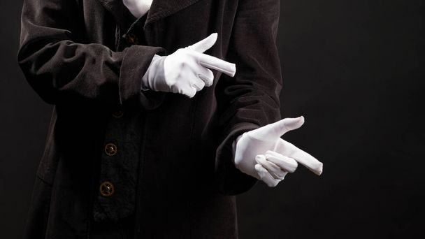 Hand gestures. Showman or magician illusionist in white gloves on a black background. - Foto, Imagem