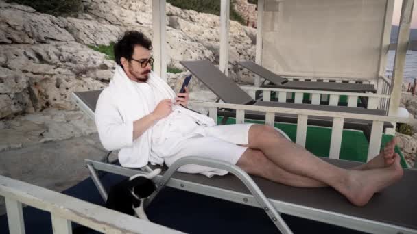 Man is resting on sunbed when somebody call him on smartphone and say bad news - Footage, Video