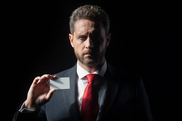Confident businessman with credit card. Middle-age business man in formalwear suit isolated on black. - Foto, Imagem
