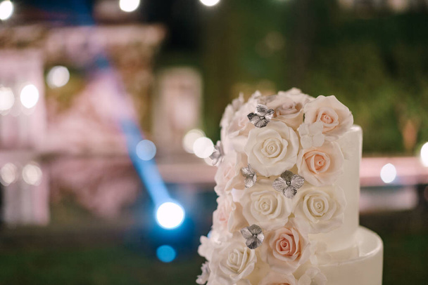 Top poziom białego tortu weselnego ozdobione różami - Zdjęcie, obraz