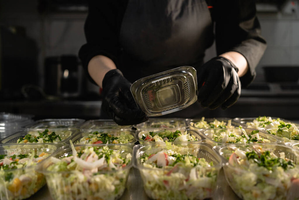 Livraison de nourriture saine. salade saine biologique dans un bol jetable. Concept d'aliments propres, aliments sains, le chef couvre les boîtes à lunch. espace de copie. - Photo, image