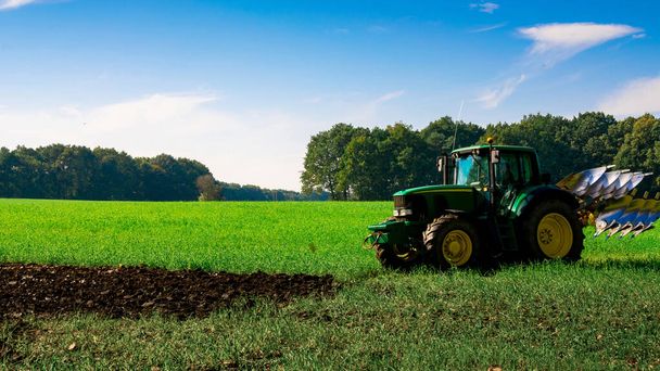 Traktor naplemente. Mezőgazdasági mezőgazdasági mezőgazdasági gépek a tájvédelmi területen. Mezőgazdasági gépek berendezése növénytermesztéshez. Kombinálja a betakarítás fogalmát - Fotó, kép