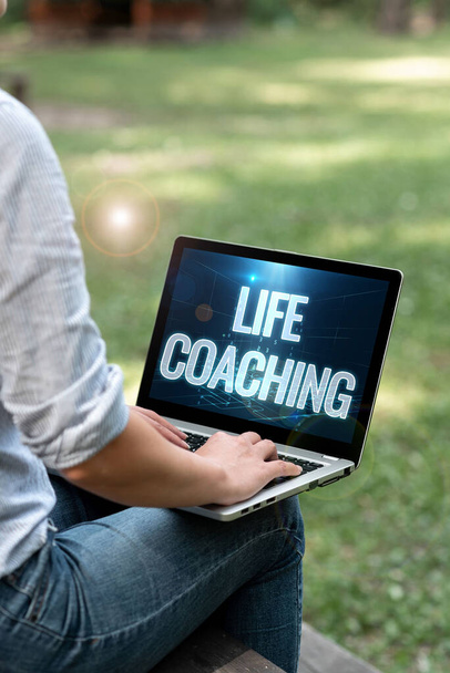 Text showing inspiration Life Coaching. Business approach Improve Lives by Challenges Encourages us in our Careers Woman Typing On Laptop Sitting Outside Side View Working From Home. - Foto, Bild