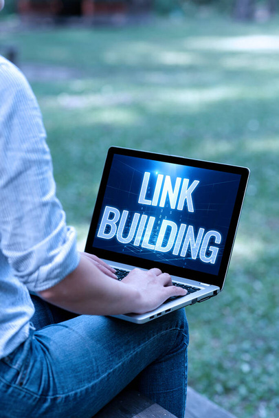 Text sign showing Link Building. Concept meaning SEO Term Exchange Links Acquire Hyperlinks Indexed Woman Typing On Laptop Sitting Outside Side View Working From Home. - Photo, Image
