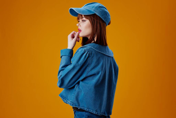 Портрет чарівної леді в шапці і джинсовій куртці, що позує кольоровий фон незмінним
 - Фото, зображення