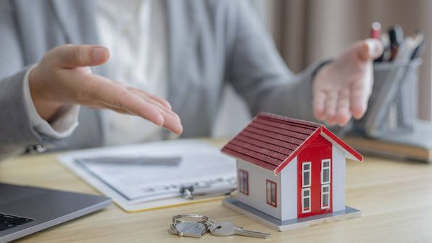 Selling a house with insurance, Sales managers or dealers have signed approval to open a housing project with a model house, Home-Real Estate and Insurance concept. - 写真・画像