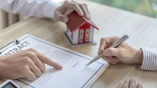 Szerződés aláírása, Home bróker vagy értékesítő lehetővé teszi az ügyfelek számára, hogy aláírja a szerződést, hogy megvásárolja a haza, mint egy törvényes lakástulajdonos, tulajdonjog átruházása, Vegyen egy új házat. - Fotó, kép