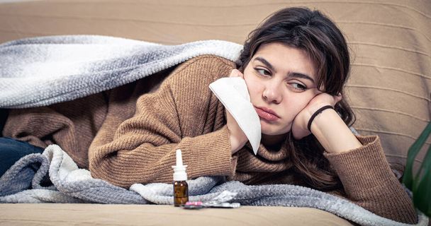Chora młoda kobieta z lekami leży w łóżku, przeziębienia i leczenia domowego. - Zdjęcie, obraz