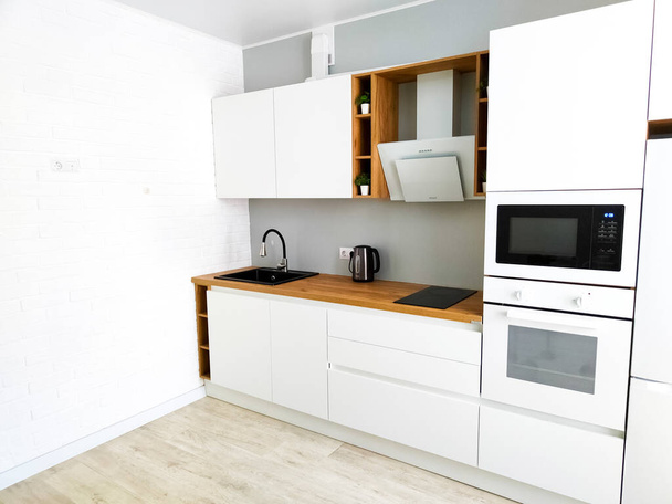 White kitchen scandinavian interior with cooker hood on wooden countertop - Photo, Image