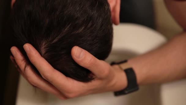 Vista macro de un hombre inclinado sobre el inodoro sintiendo náuseas y tocando la cabeza con su mano filmada - Metraje, vídeo