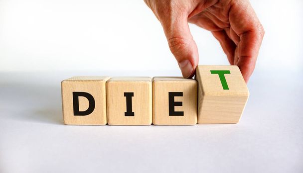 Diet instead die symbol. Doctor turns a wooden cube and changes the word die to diet. Beautiful white table, white background. Healthy lifestyle, dietology and diet instead die concept. Copy space. - Foto, afbeelding