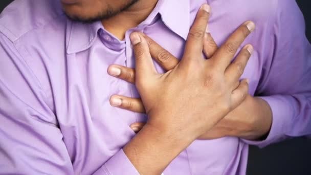fiatal férfi szenved fájdalom a szív és a kezében mellkasát kézzel  - Felvétel, videó