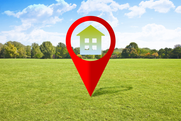 Real Estate and Building Activity concept with a vacant land on a green field available for building construction - concept with red location pin point icon - Foto, Imagen
