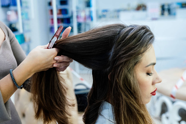 Beautiful brunette woman in a barbershop does a haircut in a beauty salon. - Foto, Imagem