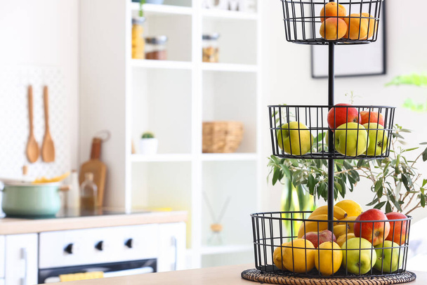 Stand with healthy fruits on counter in modern kitchen - Photo, Image