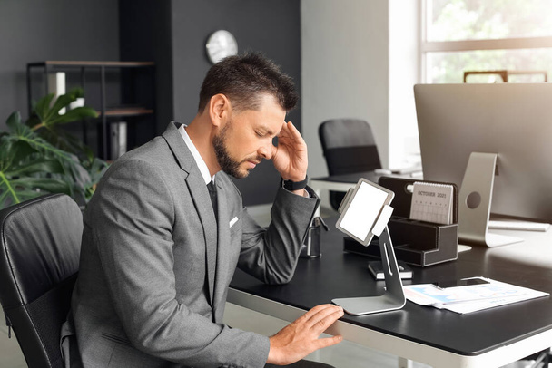 Tired young businessman working at table in office - Foto, Imagem