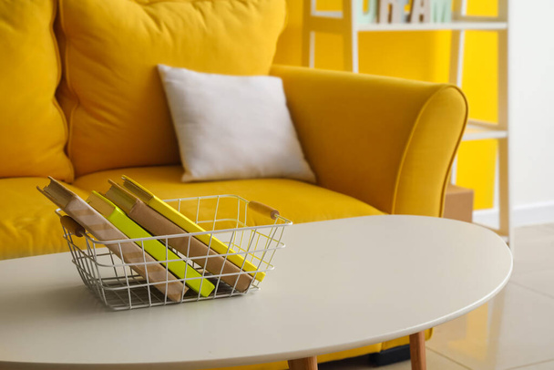 Basket with books on coffee table in stylish living room - Φωτογραφία, εικόνα
