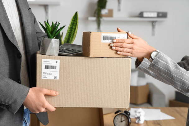 Chers collègues tenant des boîtes en carton avec des effets personnels au bureau le jour du déménagement - Photo, image