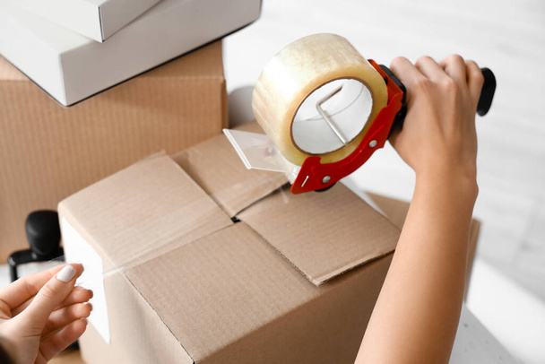 Boîte en carton d'emballage pour femme avec effets personnels au bureau le jour du déménagement - Photo, image